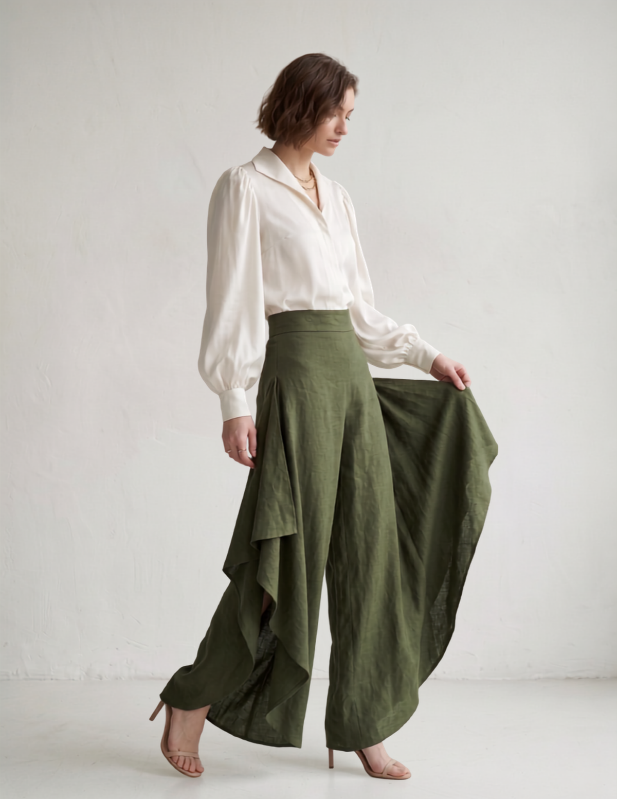 Model holding the fabric to show the deep open side slits on the Clara wide leg pants, adding movement to this easy sewing project.