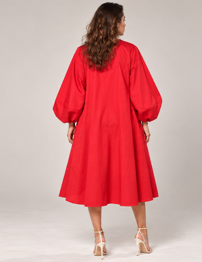 Back view of a red Lili Dress sewing pattern showing the center back seam, voluminous sleeves and flared mini dress silhouette