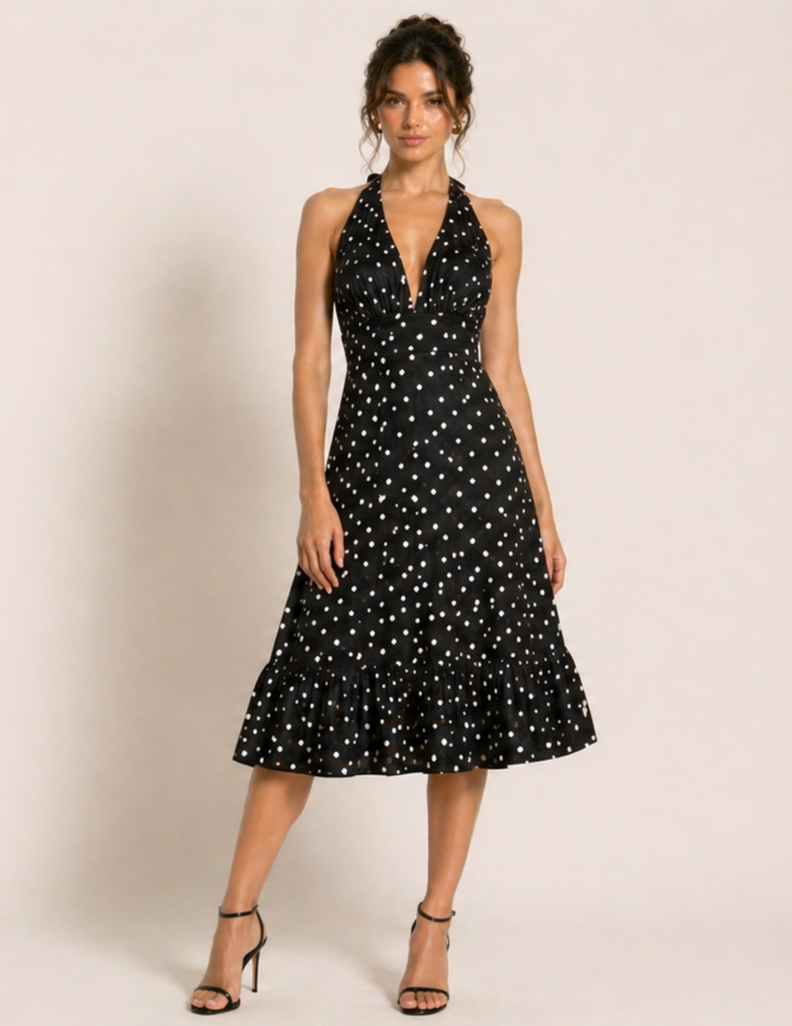 Woman wearing a black dress with white star pattern on a beige background