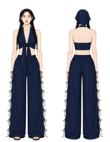 A two-view fashion illustration showing the front and back of a navy blue outfit. The front view shows a halter-style crop top with a front tie, matching wide-leg pants with side lace-up ties, and a matching head covering.