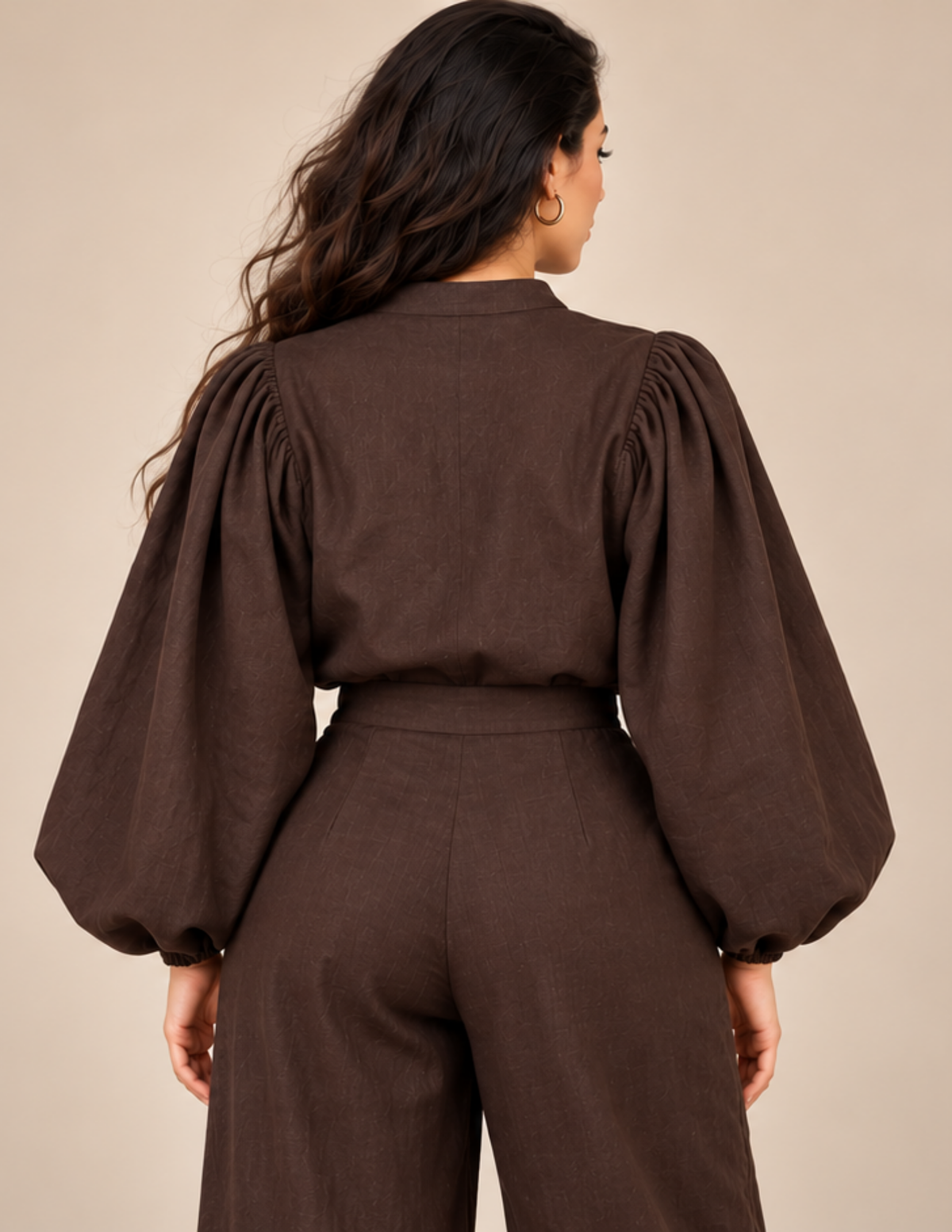Back view of a brown women's puff sleeve blouse showing the gathered 
shoulders, voluminous kimono-style sleeves, mandarin collar, relaxed back and 
elasticated sleeve cuffs.