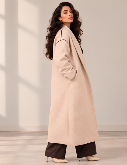 Marlie long coat sewing pattern shown 
from the side, highlighting the relaxed 
fit, dropped shoulder, long sleeve, shawl 
collar and clean flowing silhouette.