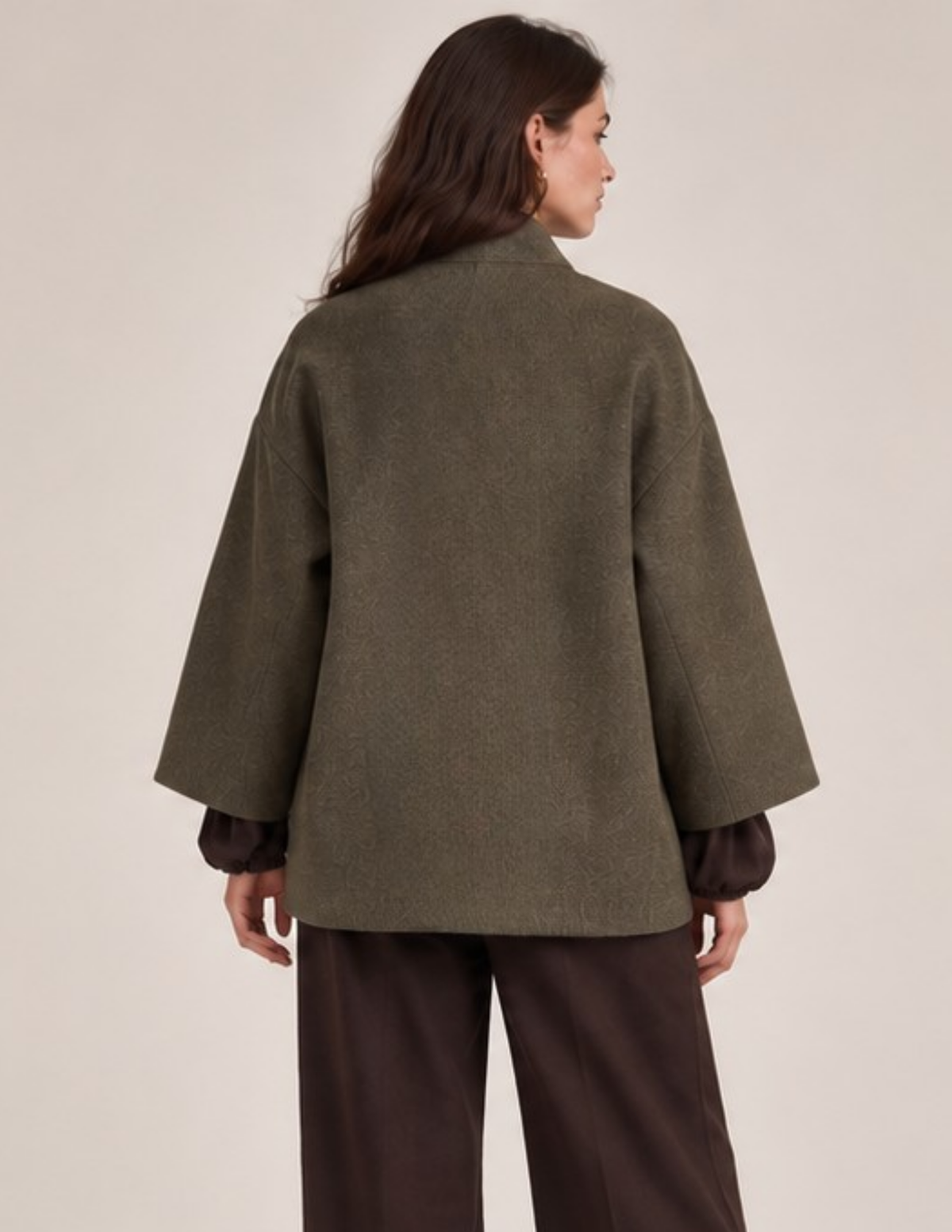 Back view of the MILDA oversized wrap coat sewing pattern showing the relaxed straight silhouette, wide sleeves, shawl collar, and olive green textured fabric