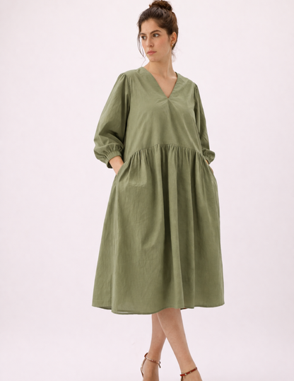 MIMA dress sewing pattern in sage green, showing the V-neckline, gathered waist, full skirt and practical side pockets