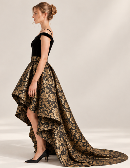 Side view of the ODETTE high-low skirt showing the shorter front hem transitioning into a long dramatic train at the back.