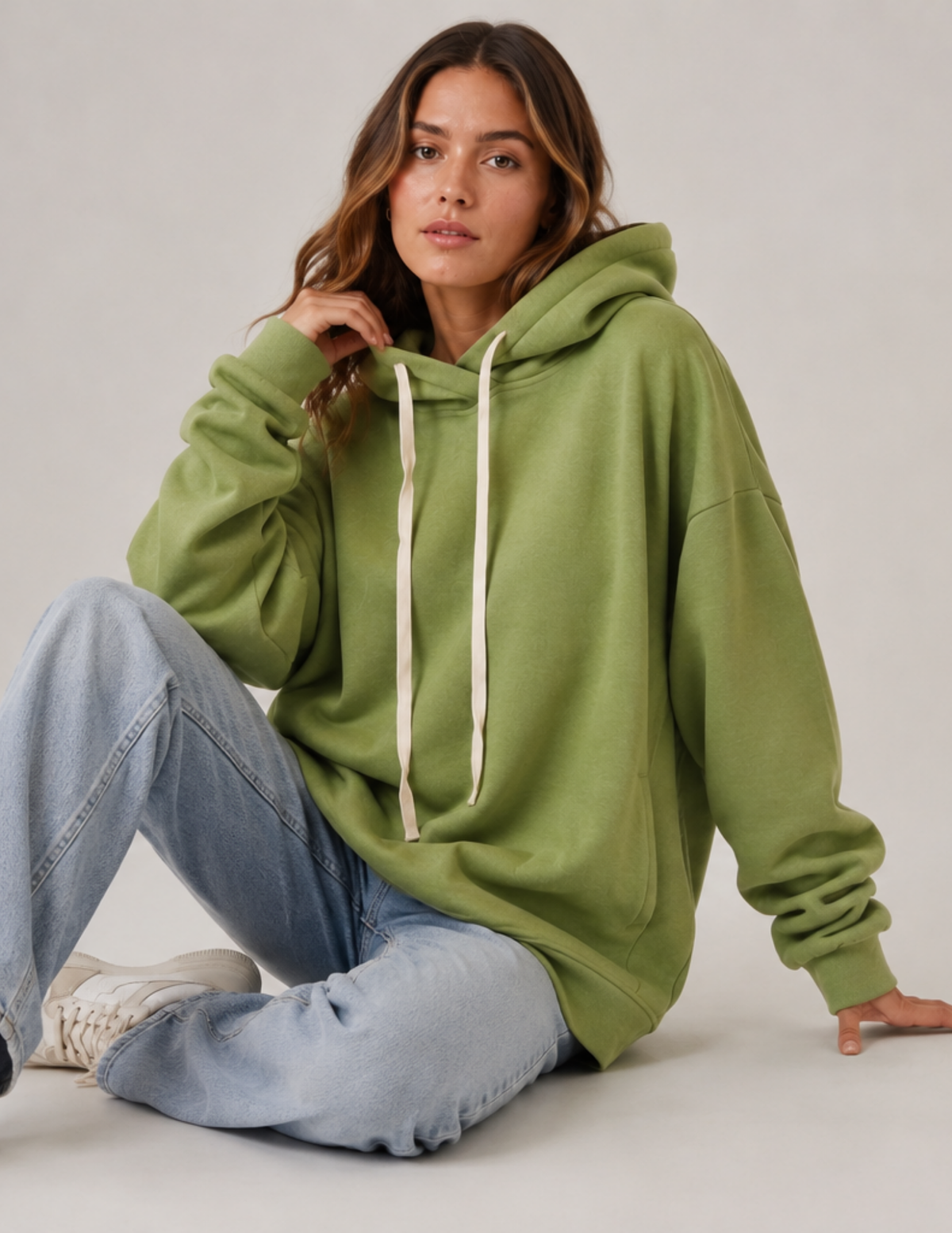 Woman wearing the OLEA oversized hoodie sewing pattern in a relaxed fit with a hood, drawstring and long 
sleeves