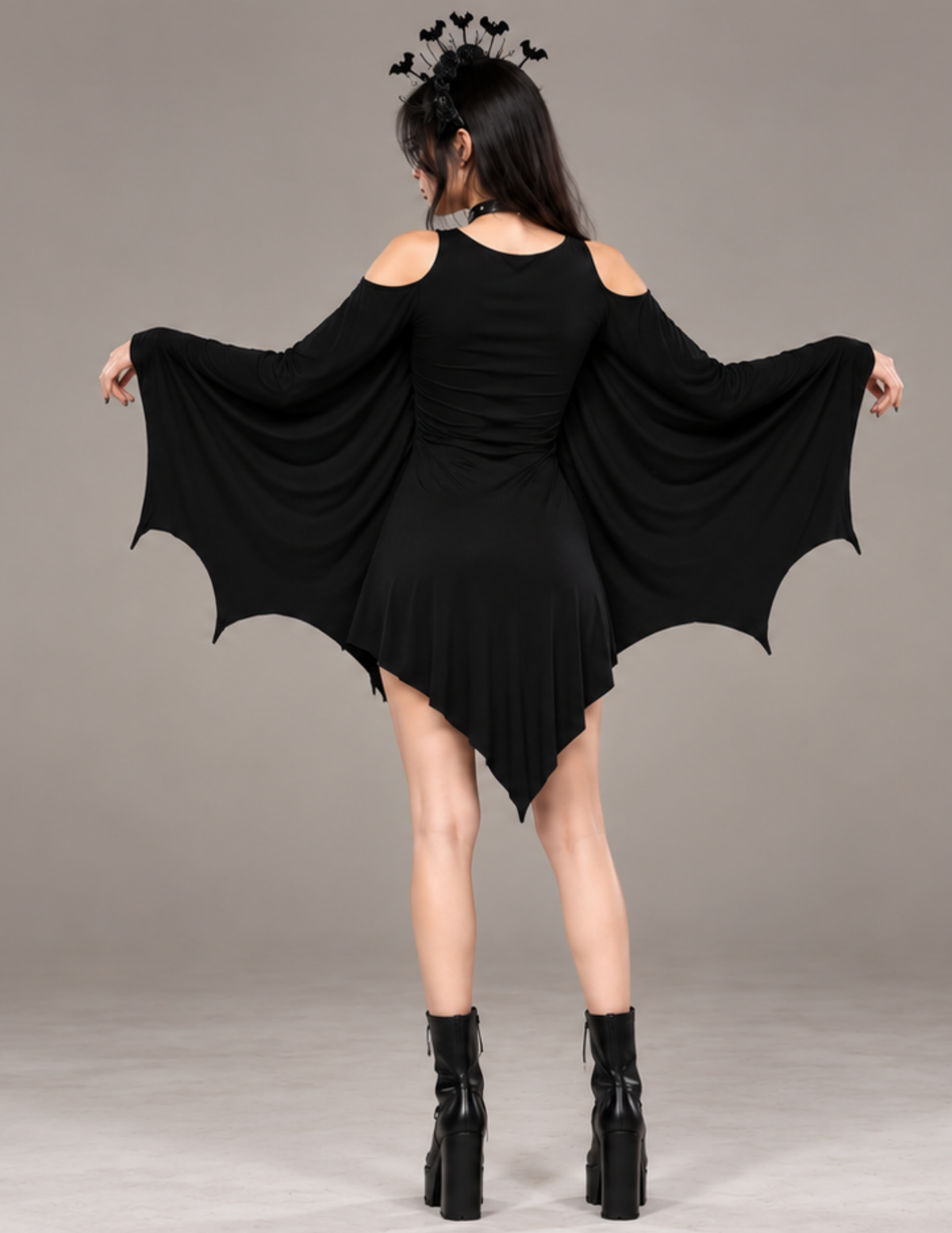 Back view of the black Raven bat wing dress 
featuring dramatic bat-shaped sleeves, cold 
shoulder cutouts and an asymmetrical pointed 
hem, showcasing the gothic Halloween costume 
design